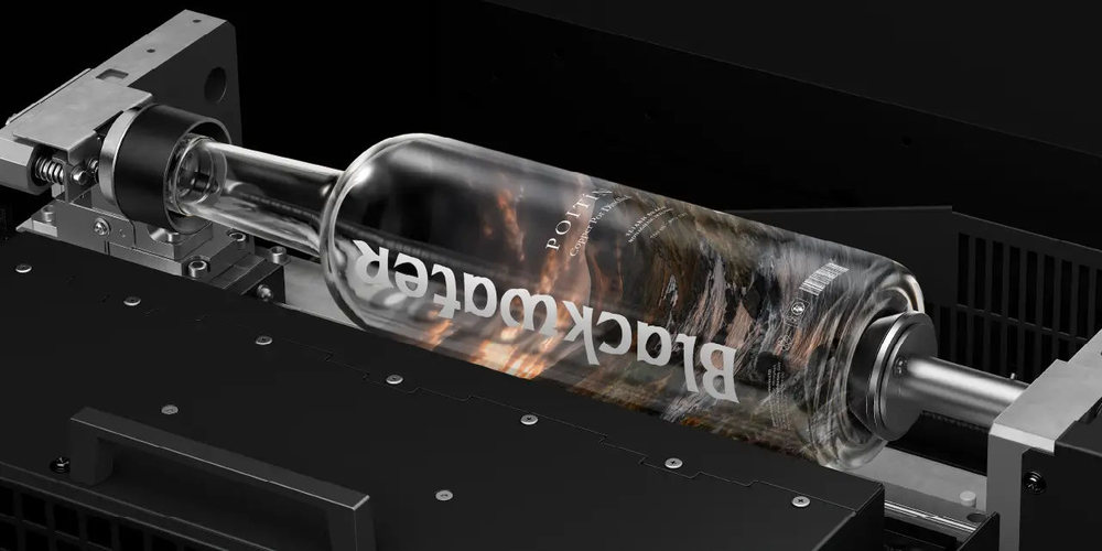Bedruckte transparente Glasflasche in der Objekthalterung des UV-Helixdruckers