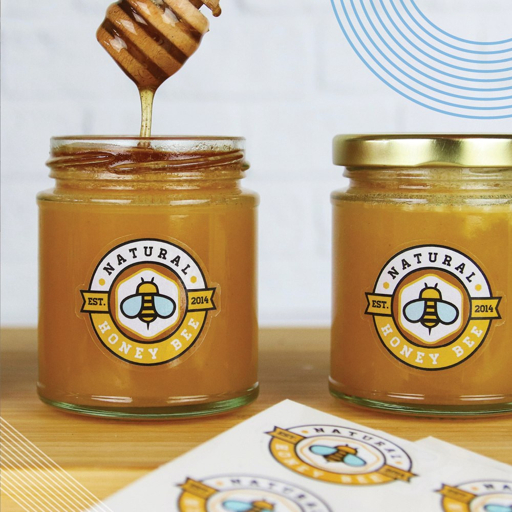 Honiggläser mit runden Produktetiketten auf der Verpackung